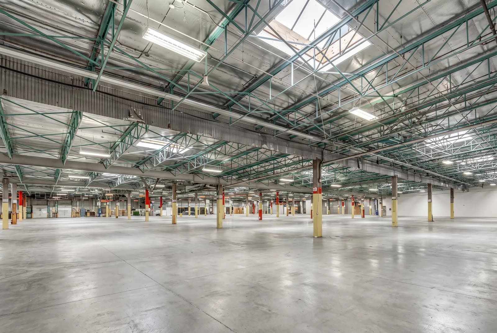 The open warehouse floor in Vancouver under green steel roof joists and skylights