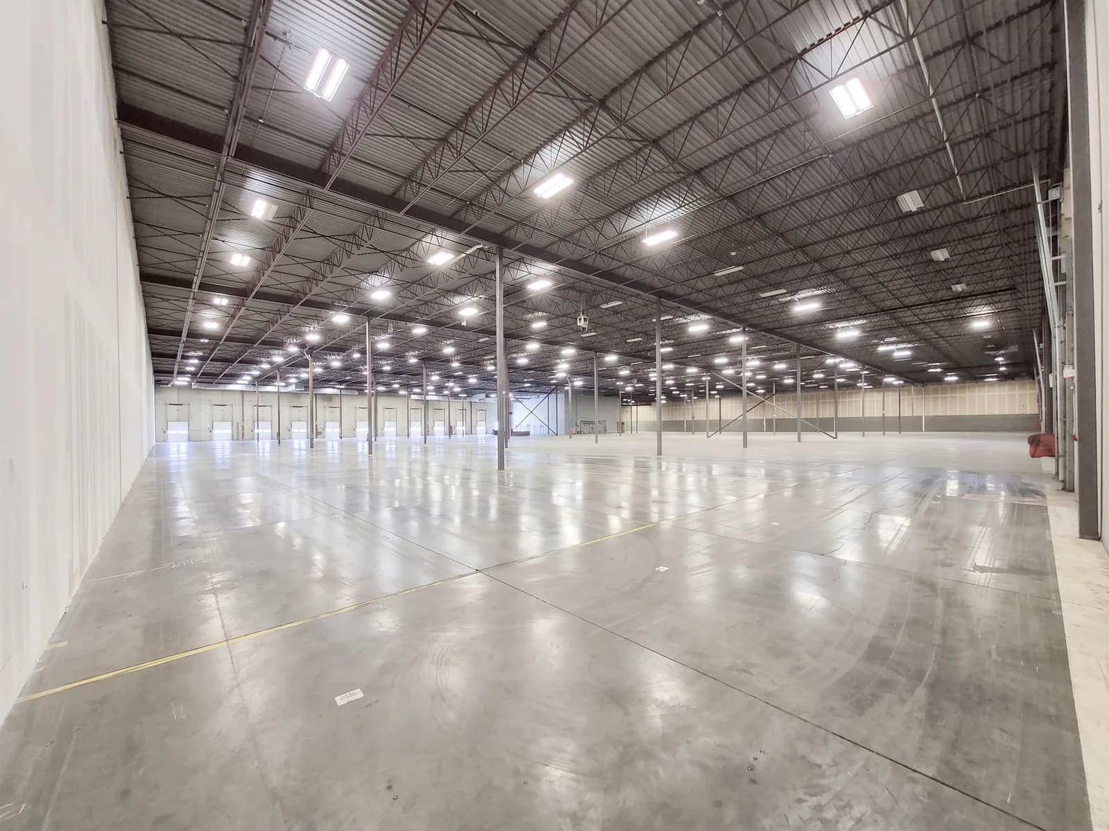 The main floor of the Rolls Right Calgary warehouse, lit bay after bay back to the dock wall